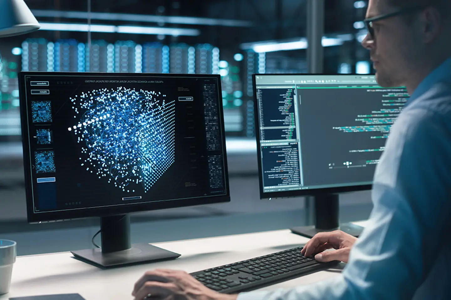 Een computeringenieur achter een bureau met een scherm waarop veel grafische gegevens worden weergegeven.