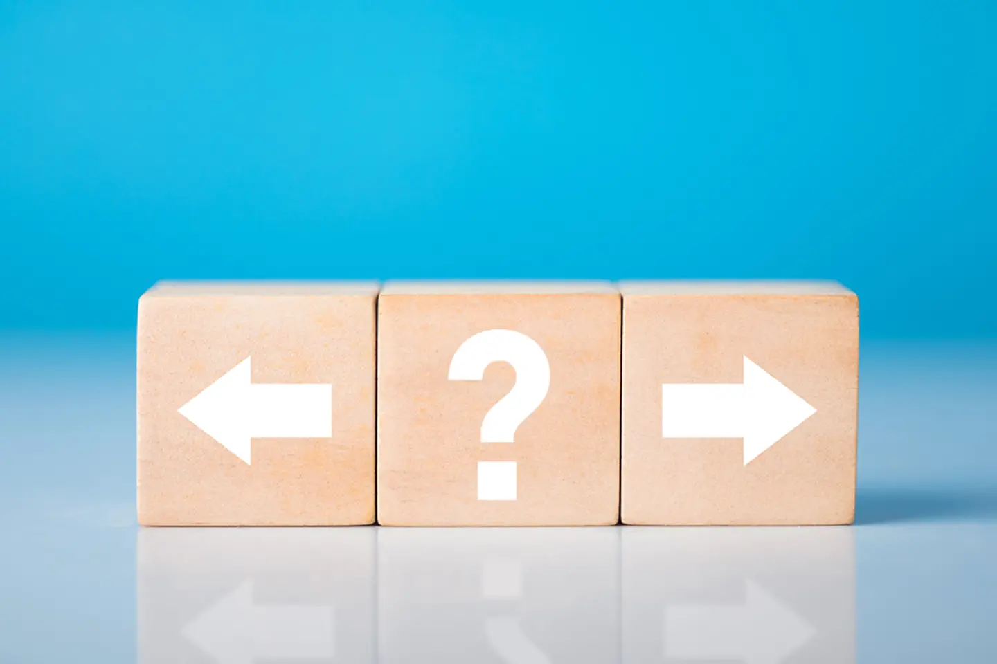 Three cubes, one with an arrow left, one with a question mark and one with arrow right