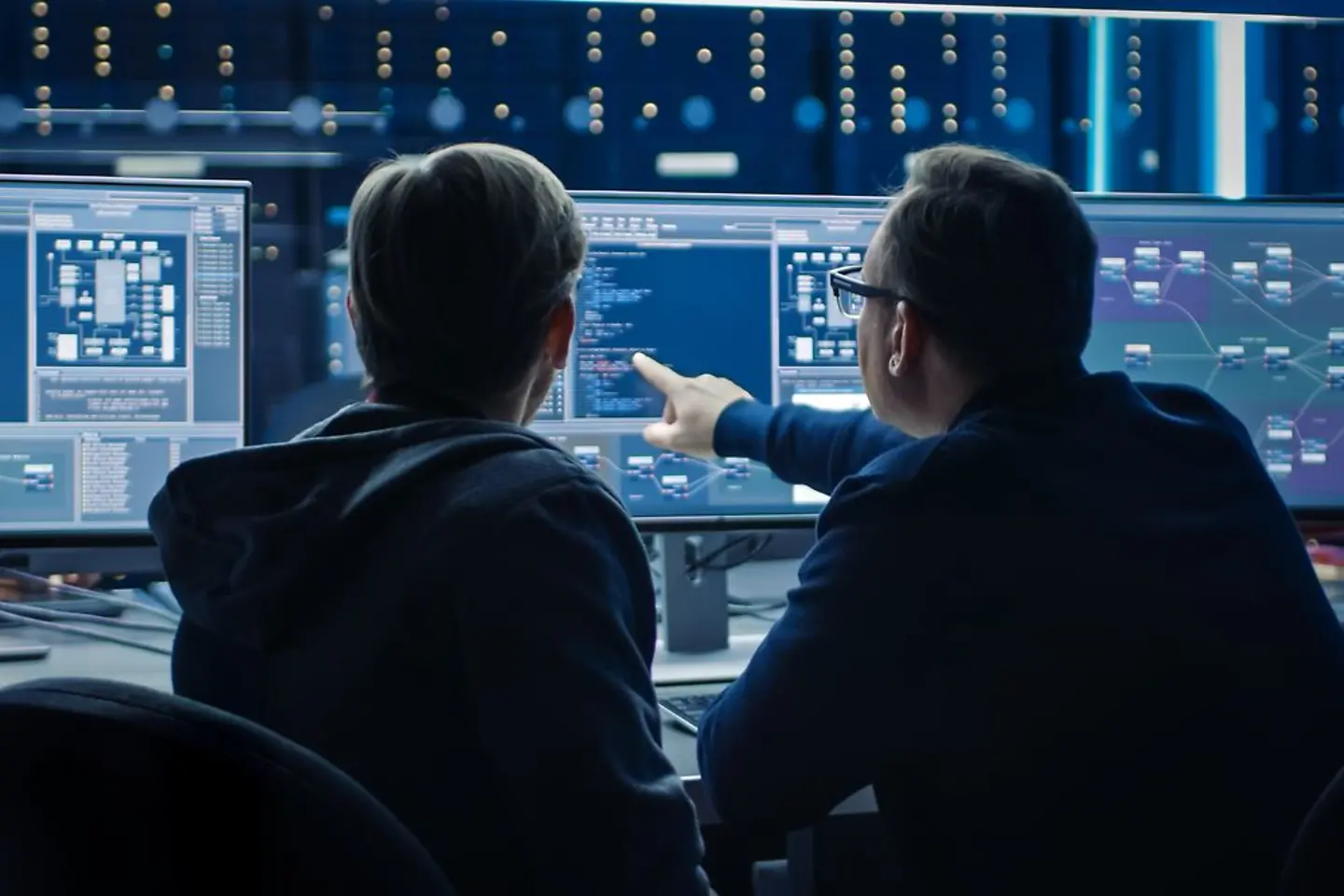 Dos expertos en software observando un análisis de datos en la pantalla de una computadora