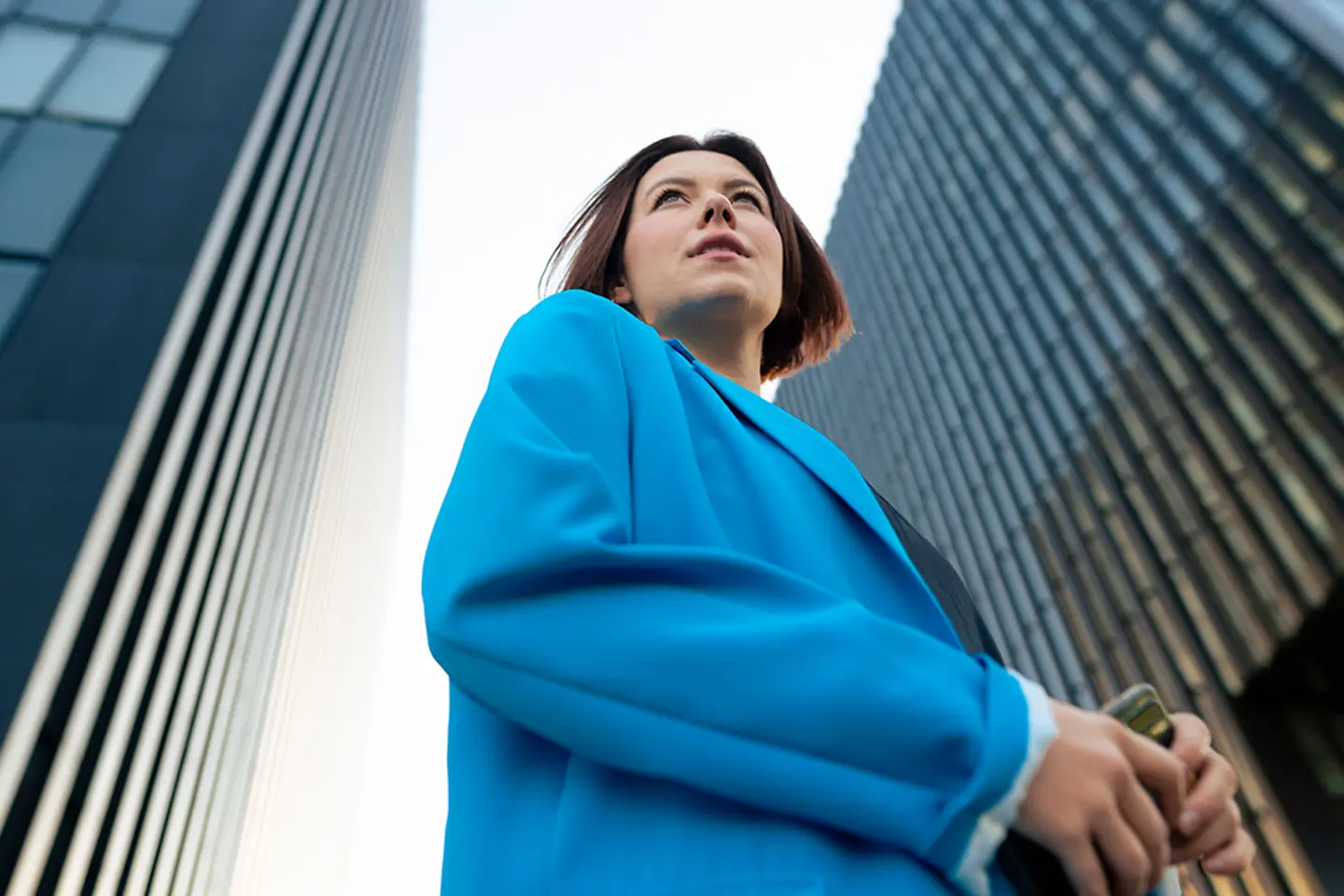 Woman stands with highrises in the background