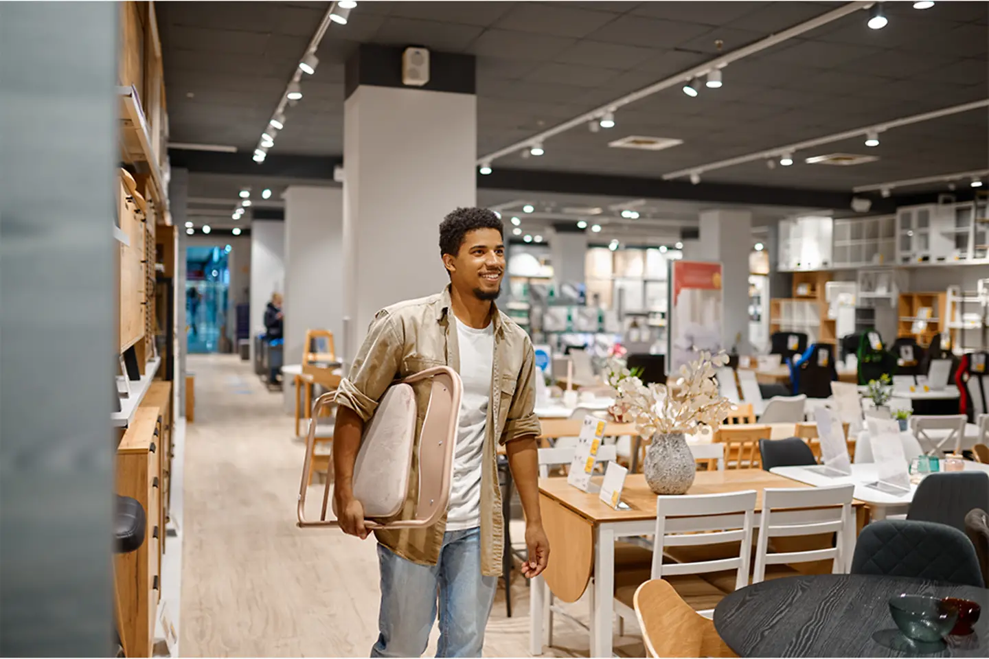 Man carrying folding chair to shop counter