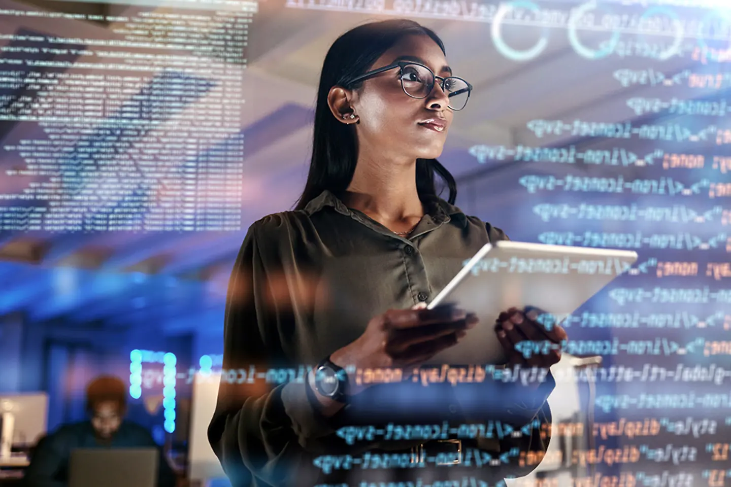 A woman programmer checks a screen with code on it.