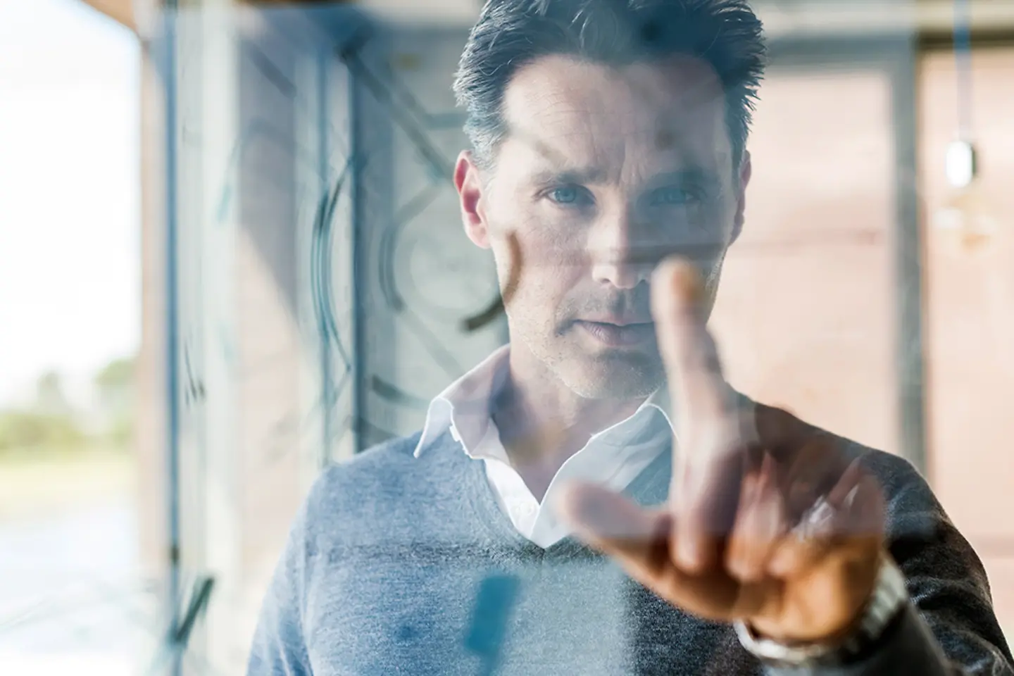 Geschäftsmann berührt transparente Projektionsfläche