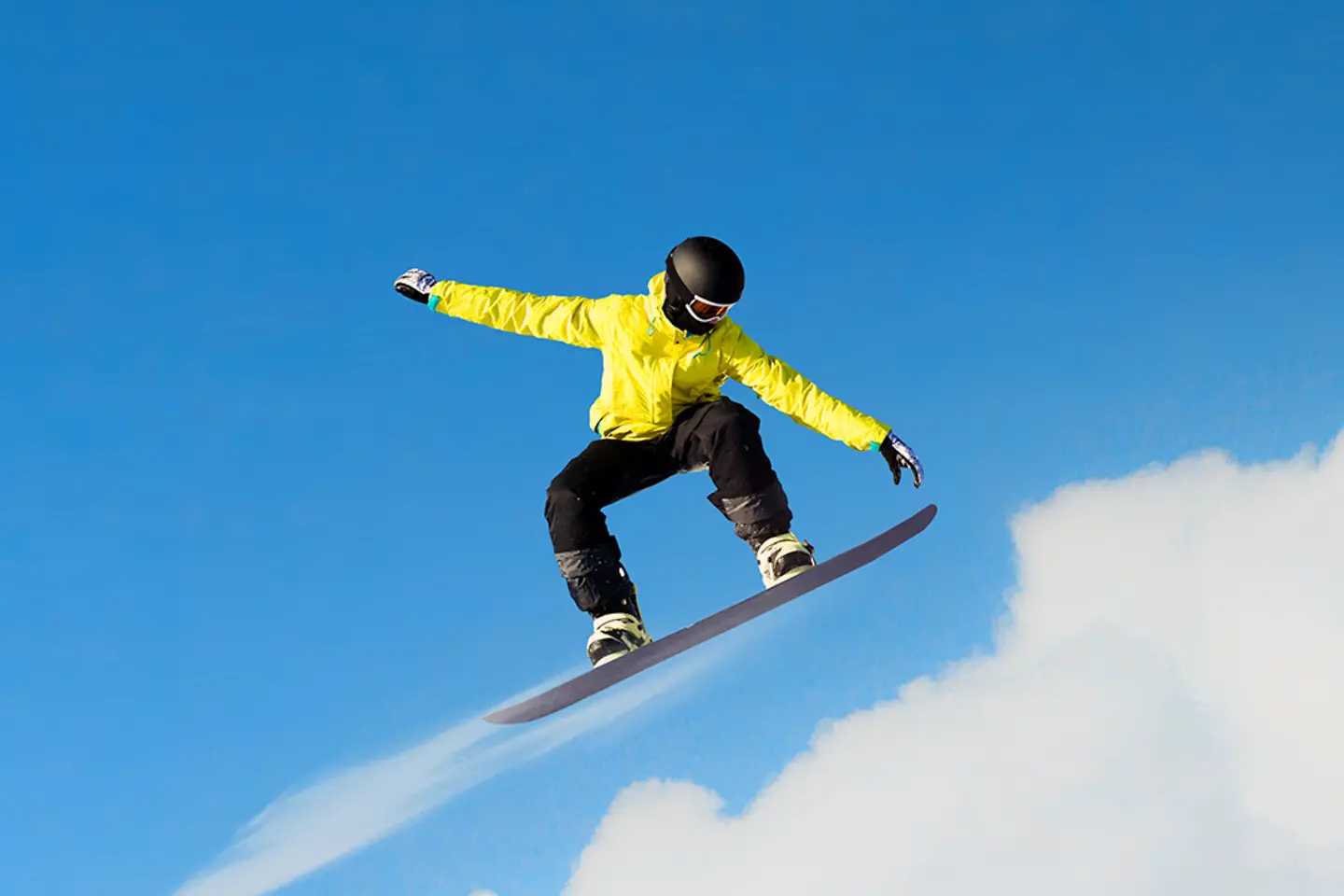 Snowboarder beim Sprung mit Wolken im Hintergrund