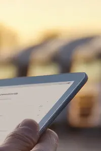 AI-generated image - Man holding tablet managing fleet logistics with trucks in the background