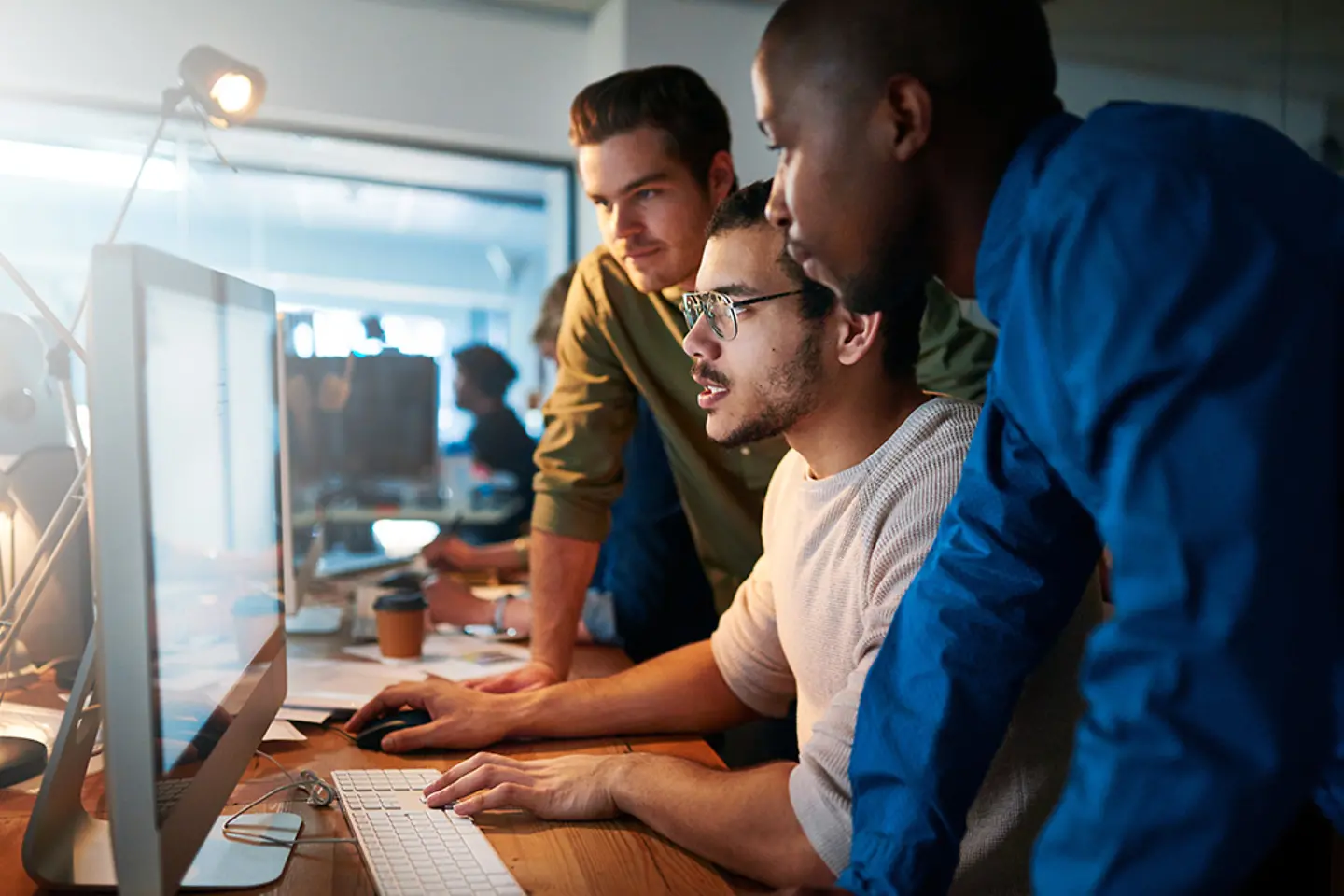 Membros de uma equipe de suporte de TI conversando em uma mesa.