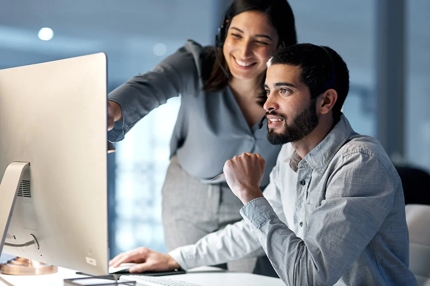 Central de atendimento: gerente e equipe de telemarketing no computador durante uma sessão de treinamento de software