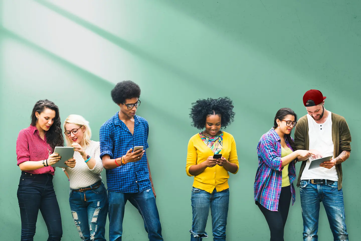 A group of young people with phones, tablets and laptop