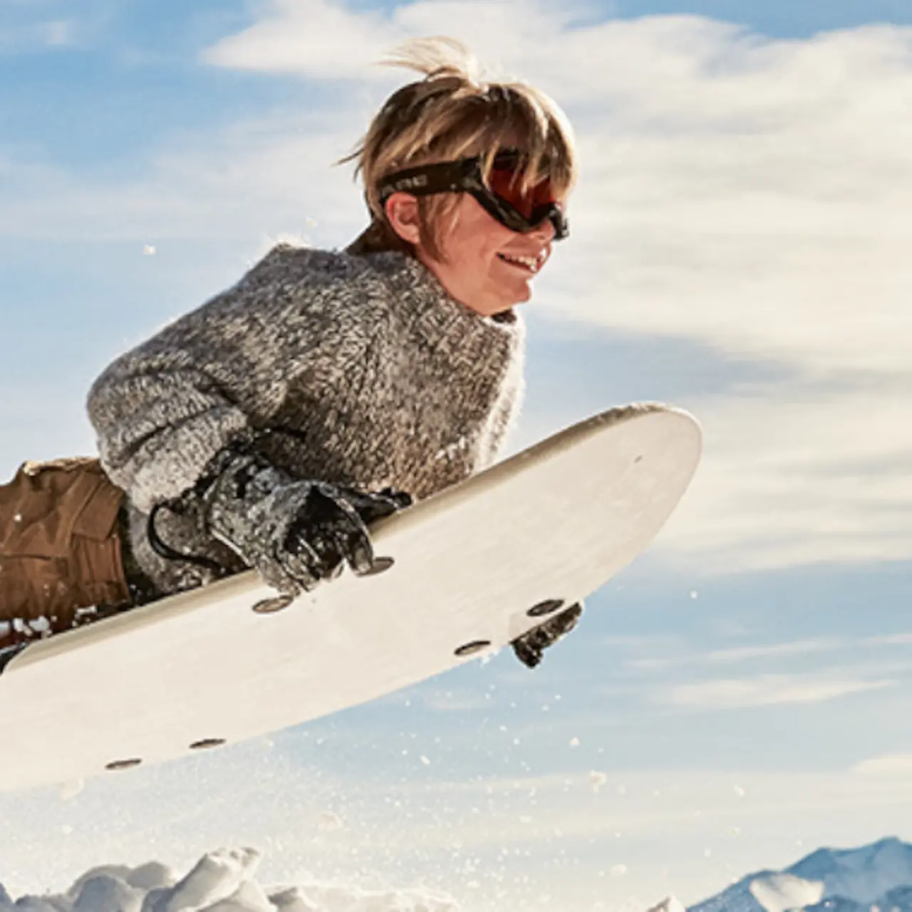 Snowboarder auf einem Surfbrett bergaufwärts