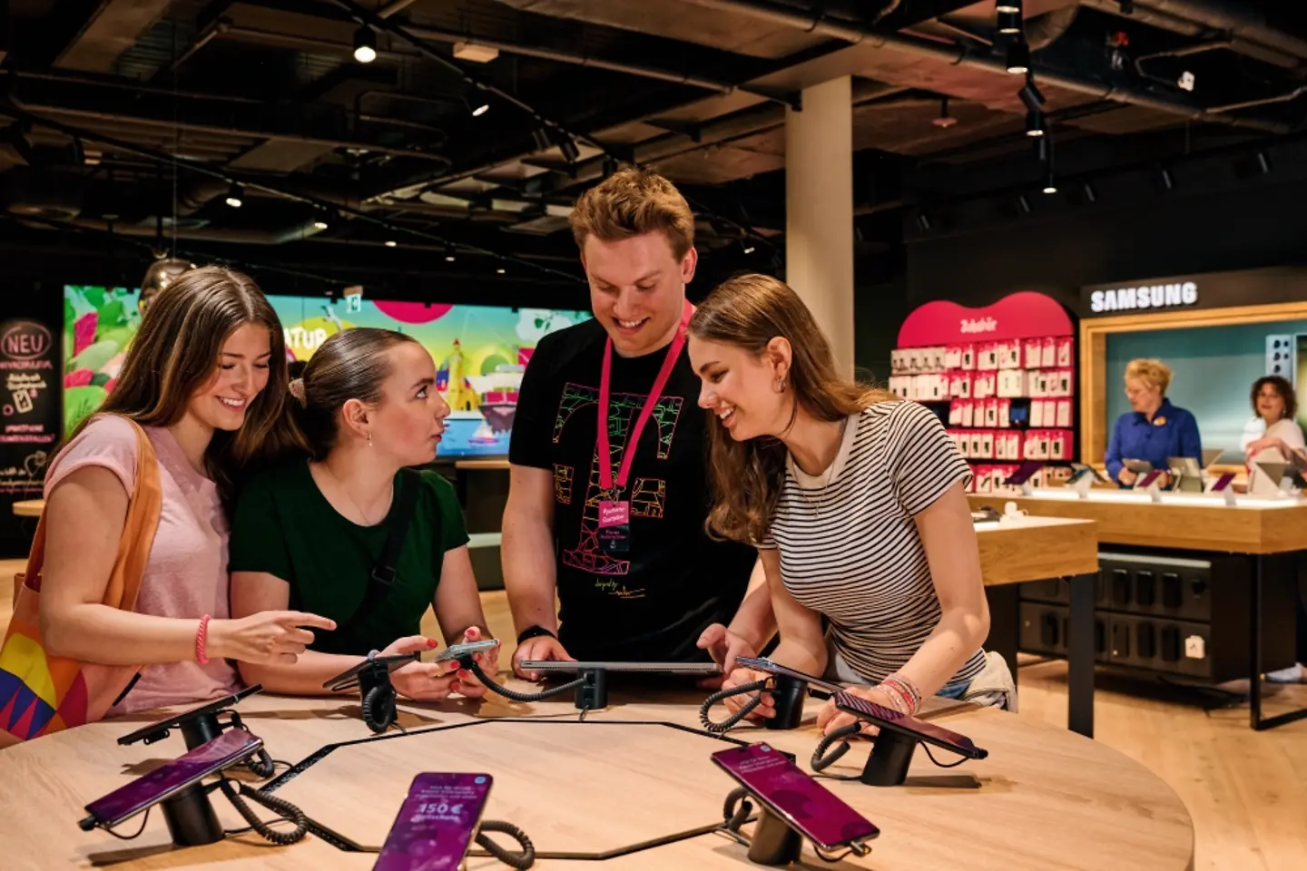 Three female customers are advised by employees on mobile phones in a flagship store