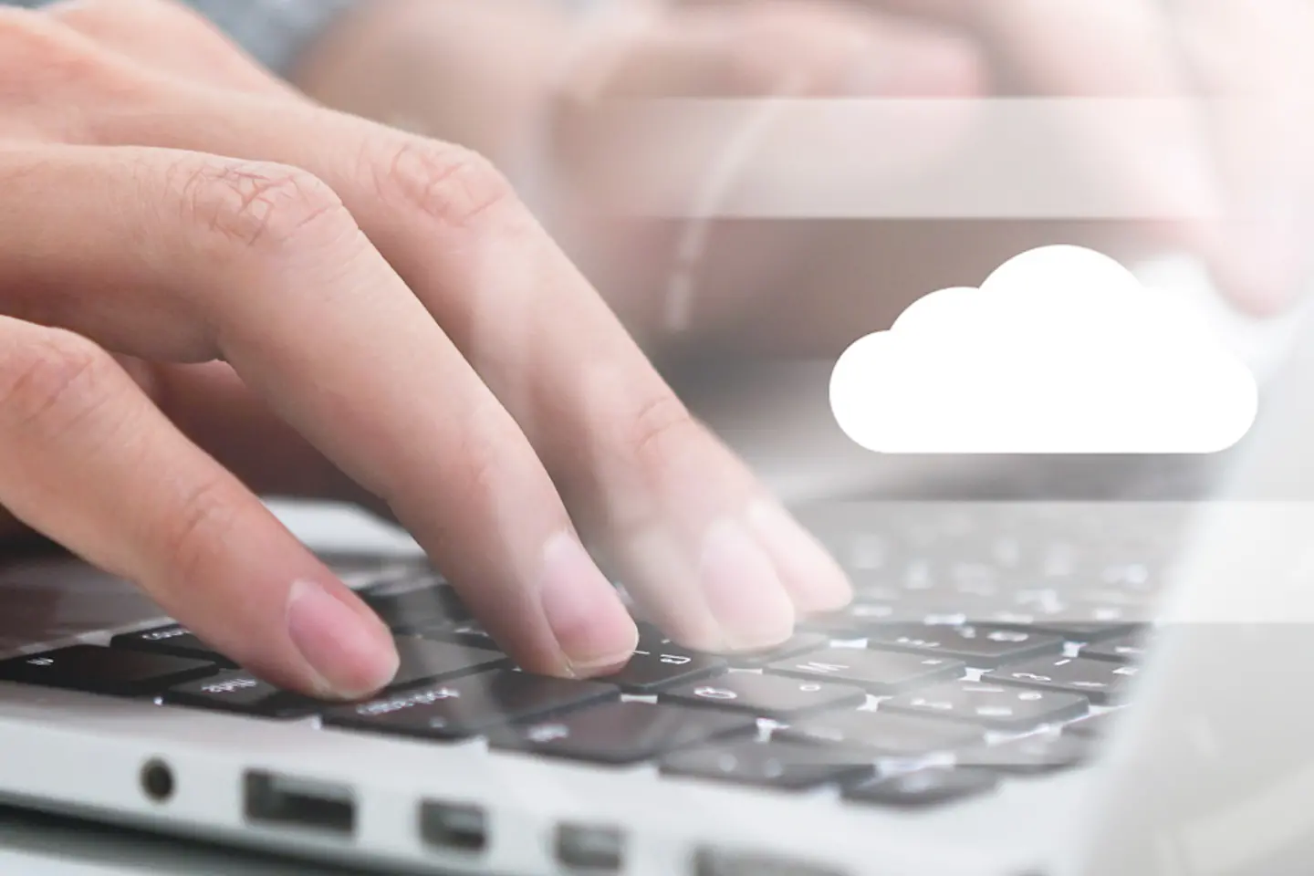 Manos escribiendo en el teclado de un portátil