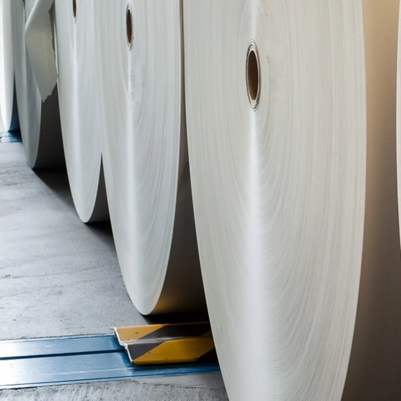 Primer plano de varios rollos de papel grandes en una sala
