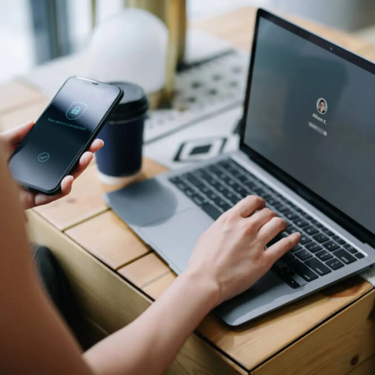 Person, die Smartphone und Laptop gleichzeitig benutzt