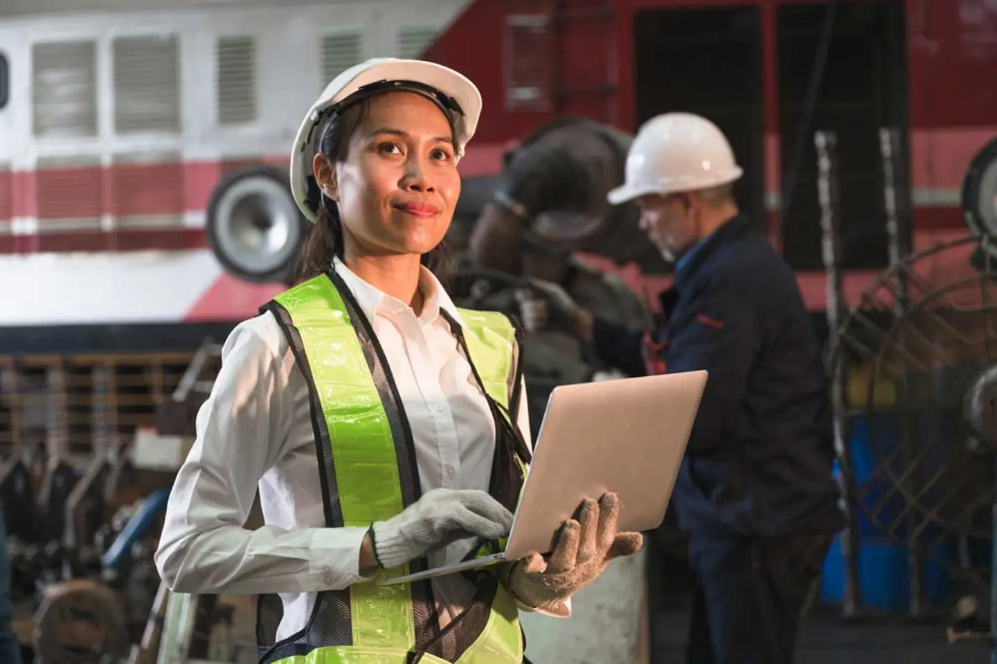 Machinist using digital laptop in factory