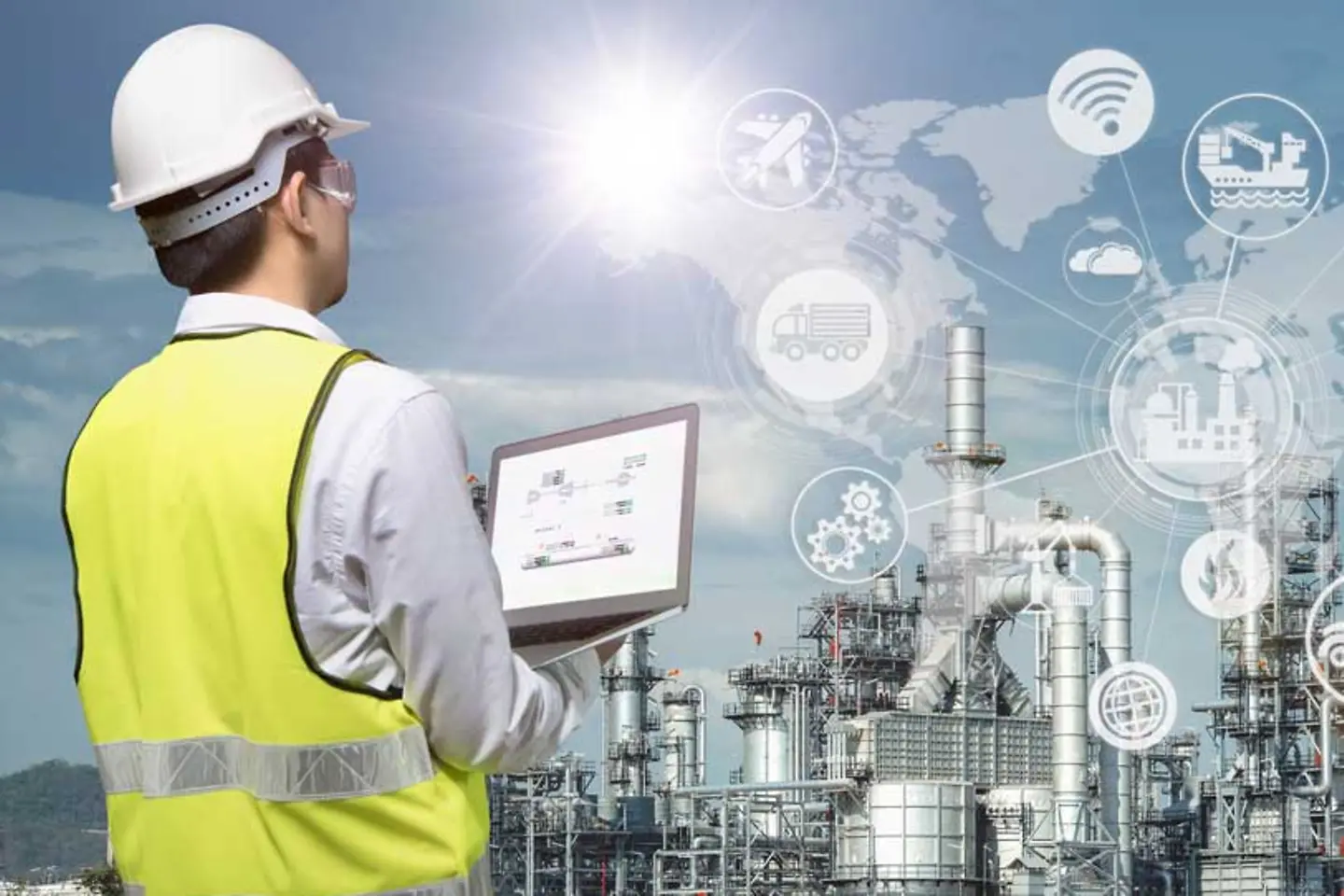 An engineer with a laptop working in a refinery