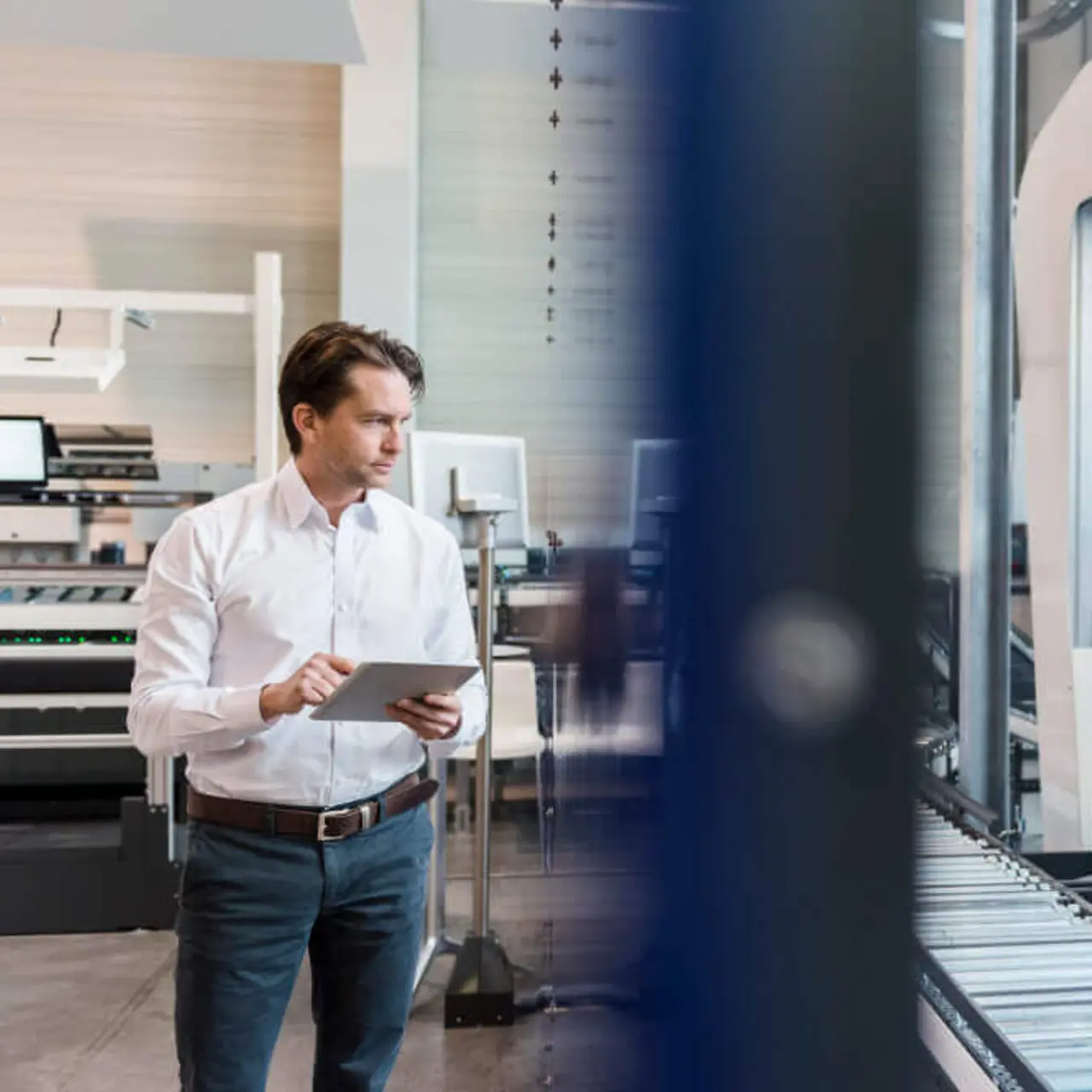 Businessman using tablet at conveyor belt in factory