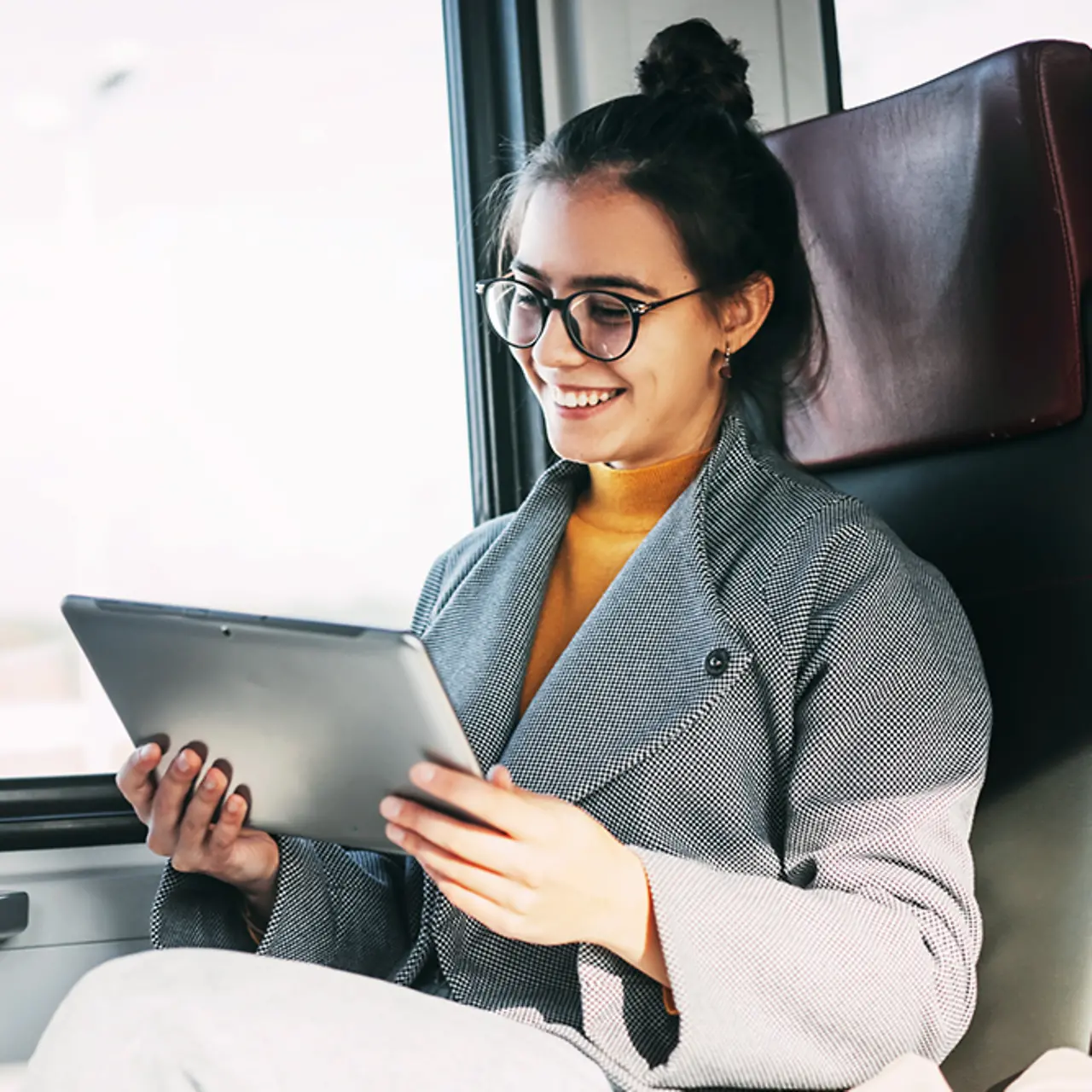 Junges Mädchen im Zug, das ein Tablet benutzt