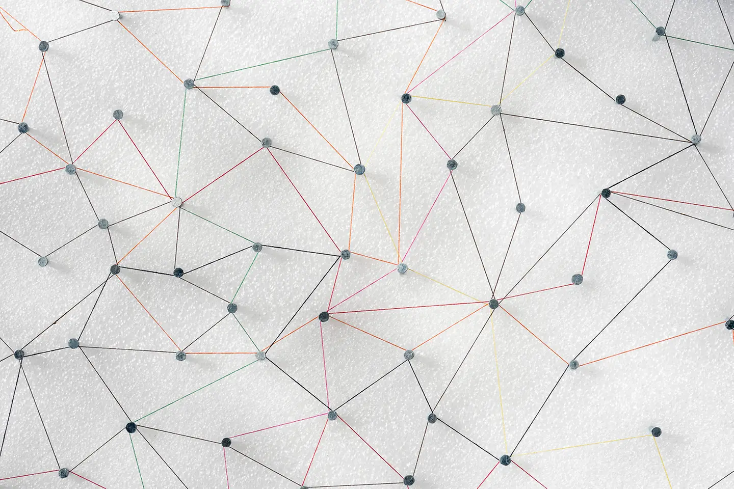 Network of threads with pins fixed on white styrofoam