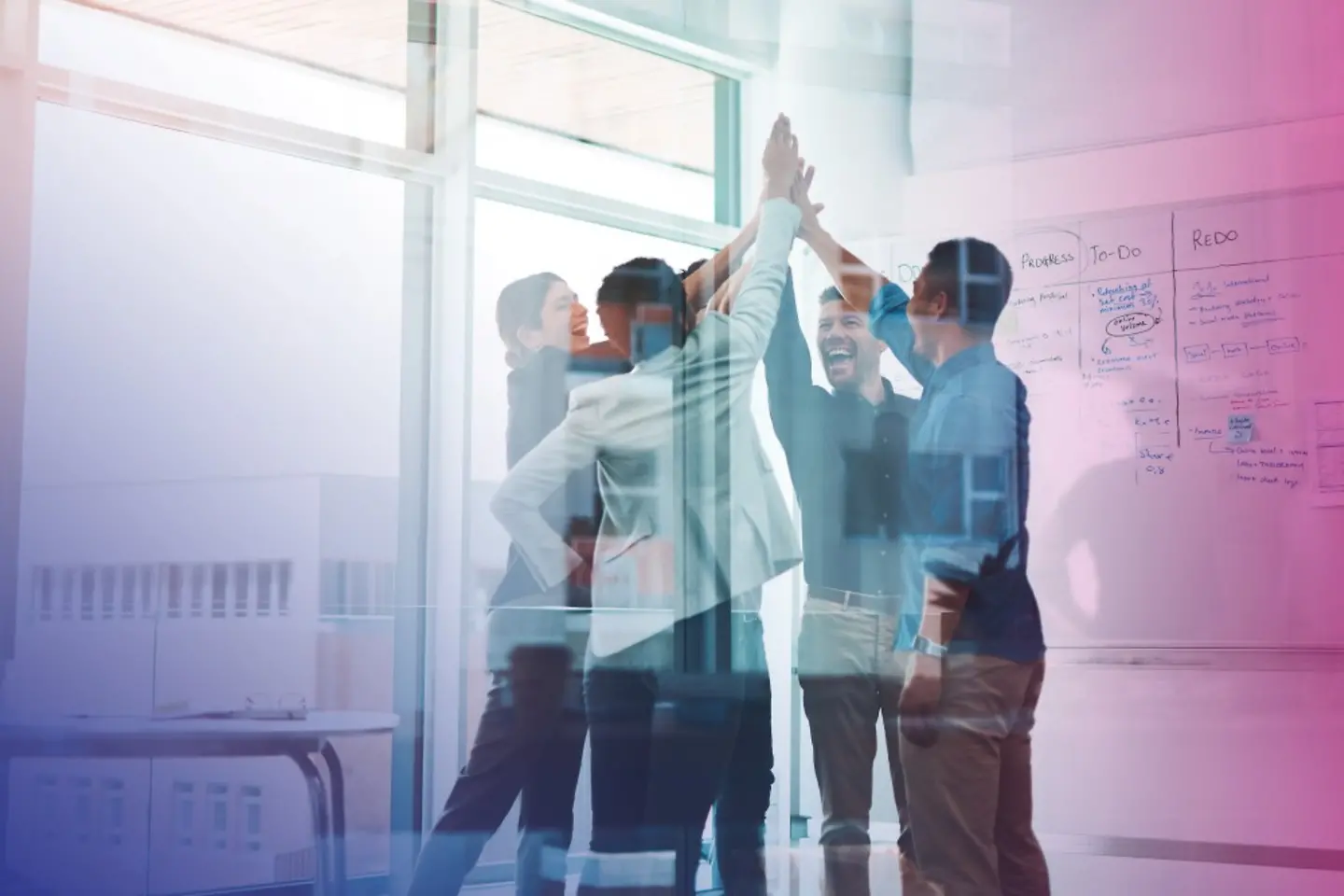 Group of young business people joining hands in solidarity in a modern office
